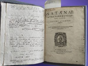 A book opened to the title page (Jacobus Acontius, Satanae stratagemata: libri octo … (Basel, 1565)), showing handwritten annotations on the left-hand page from the Library's founding donor Joshua Wilson. 